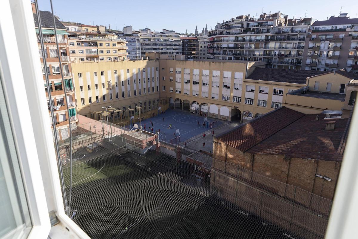 En primer plano, la pista descubierta precintada por ruido que los Salesians de Rocafort y el Centre Esportiu Rocafort comparten en el Eixample, en Barcelona.