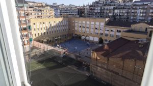 En primer plano, la pista descubierta precintada por ruido que los Salesians de Rocafort y el Centre Esportiu Rocafort comparten en el Eixample, en Barcelona.