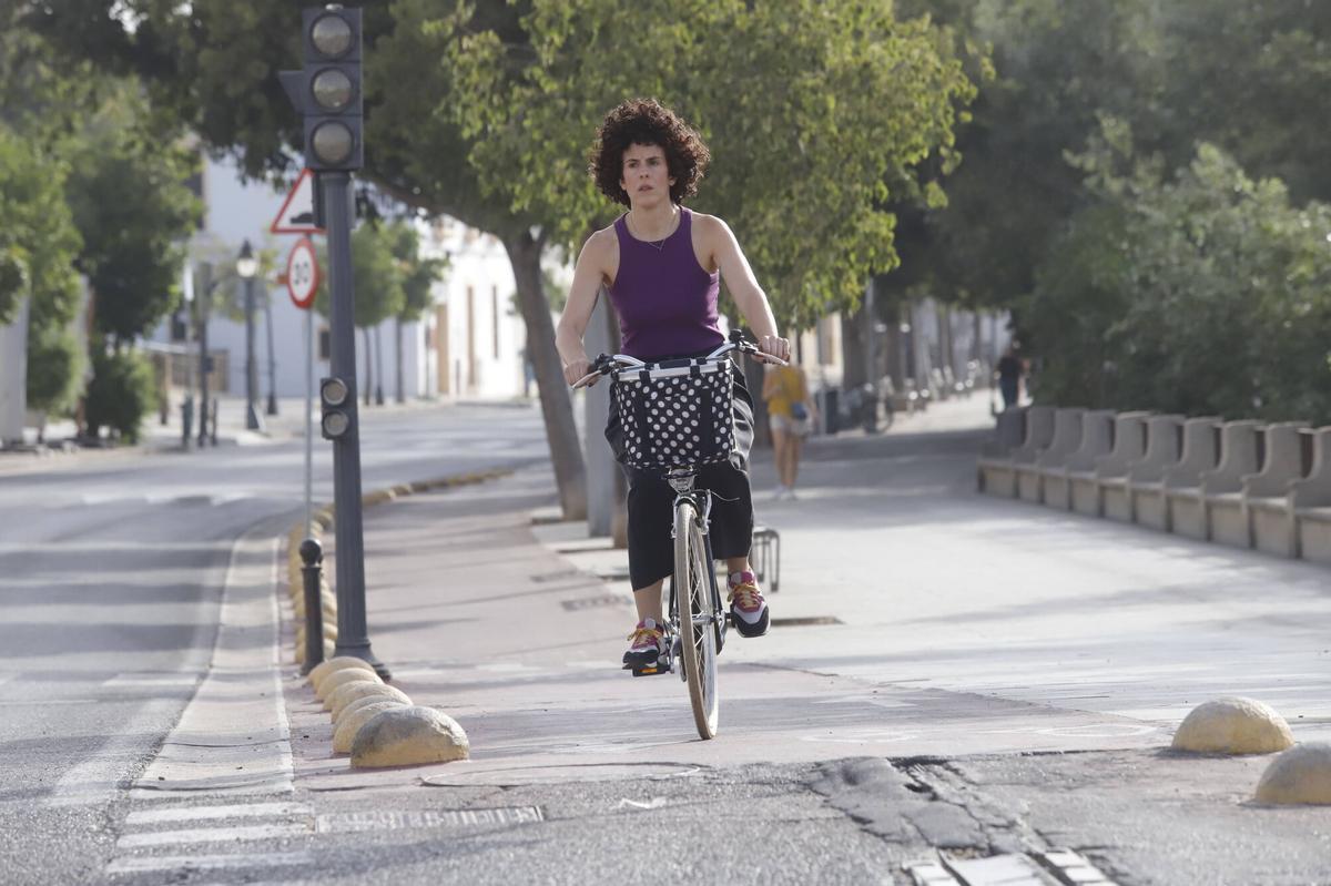 Una mujer circula en bicicleta por el carril bici de la Ribera.