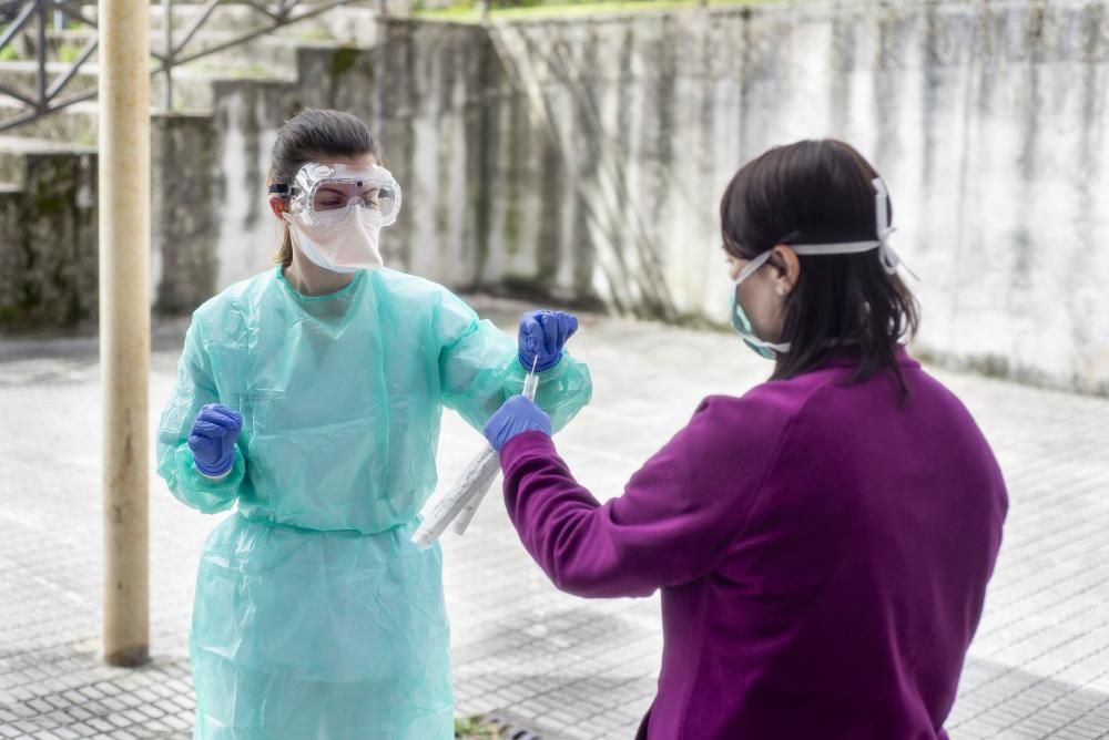 Una enfermera del CHUO realiza una prueba a una mujer en la zona habilitada para el test del coronavirus. // Carlos Peteiro