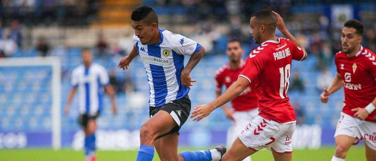 El blanquiazul César Moreno conduce el balón durante el partido ante el Murcia en el Rico Pérez. | HCF