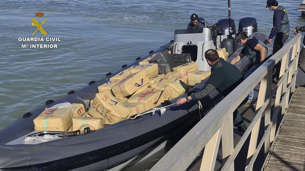 Agentes de la Guardia Civil se incautan de una lancha llena de fardos de hachís durante una operación en las costas de Cádiz.