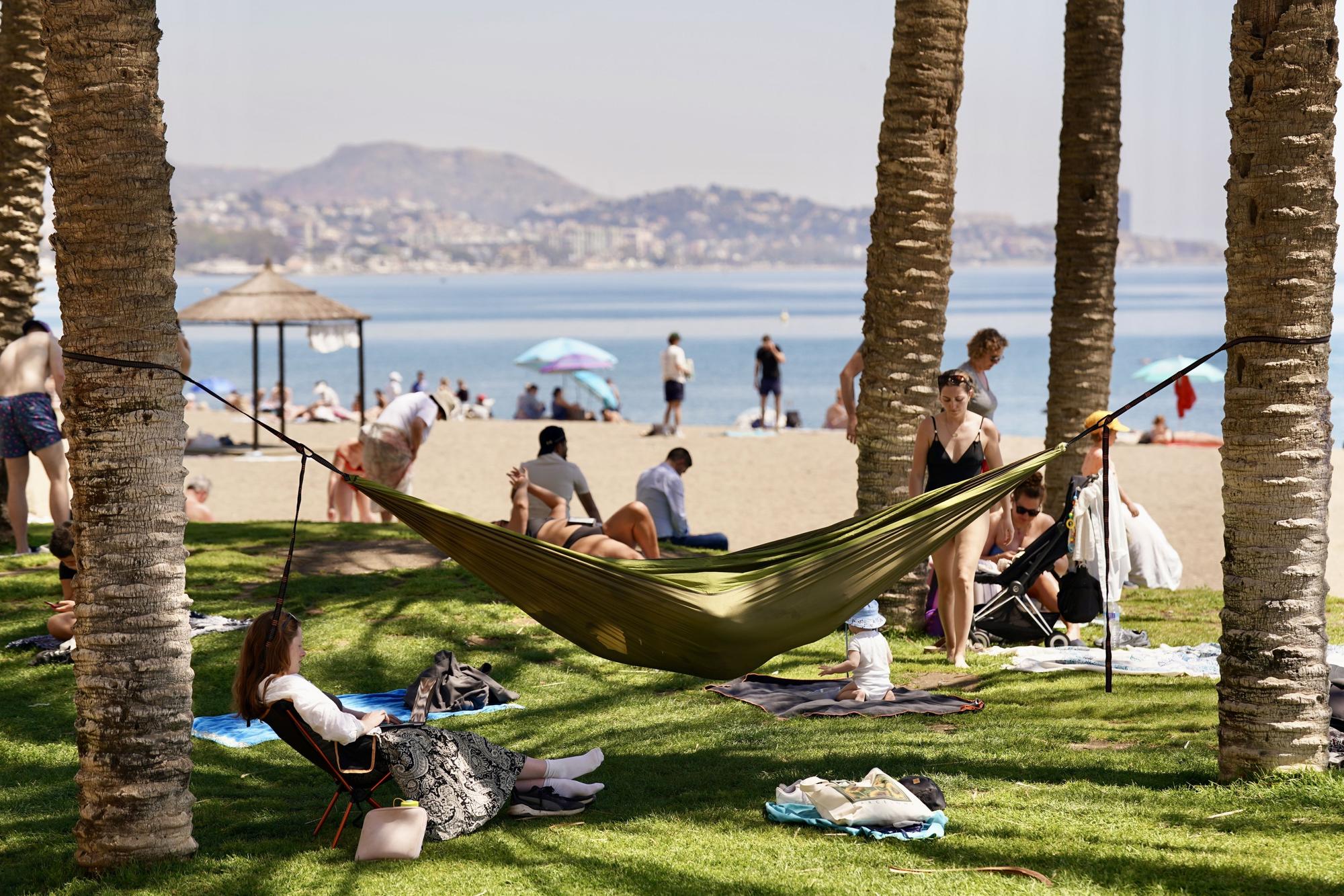 Bañistas y turistas disfrutan del sol y el calor en la playa de La Malagueta a mediados de abril.
