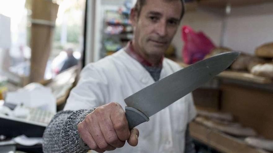 El propietario del establecimiento muestra el cuchillo con el que defendió la empleada. // Brais Lorenzo