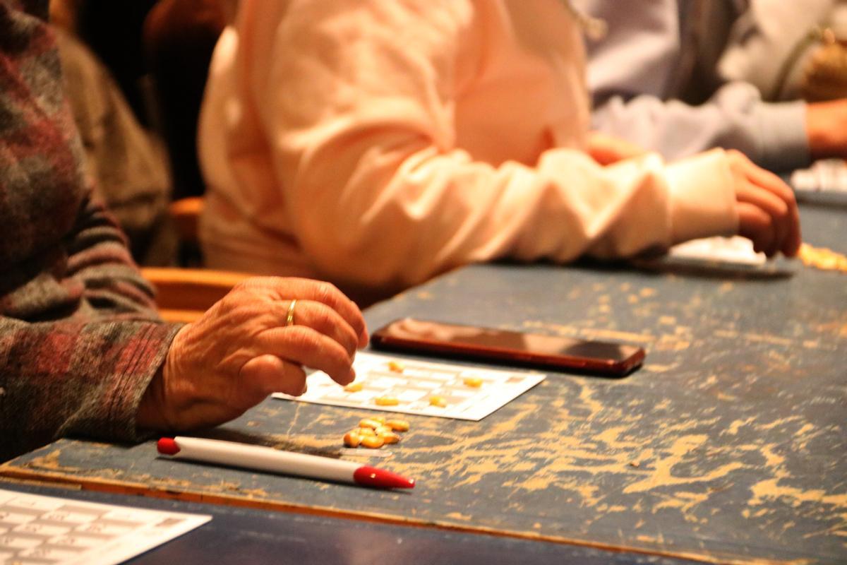 Pla curt de les mans d'una senyora jugant a la quina de Palafrugell aquest diumenge 5 de desembre de 2021. (Horitzontal)