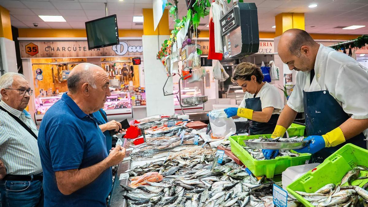Pescaderos atienden a clientes en el mercado de O Calvario, en Vigo.