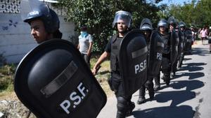 Agentes de policía llegan al lugar en el que un grupo de vecinos han destruido la casa de un supuesto traficante de drogas en Rosario, Argentina, en las protestas por la muerte el sábado de un niño en la calle durante un tiroteo.