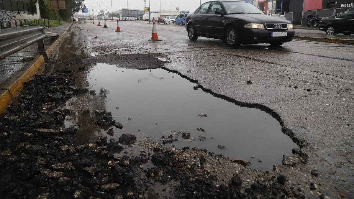 Socavón en la calzada de la avenida Agrupación Córdoba, el viernes, señalizado con conos de plástico para evitar problemas al tráfico. El Ayuntamiento ya ha tomado nota y ha anunciado que actuará de inmediato.