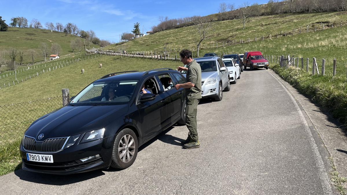 Un guarda del Principado informa a los vehículos en Demués de que no pueden acceder a la pista