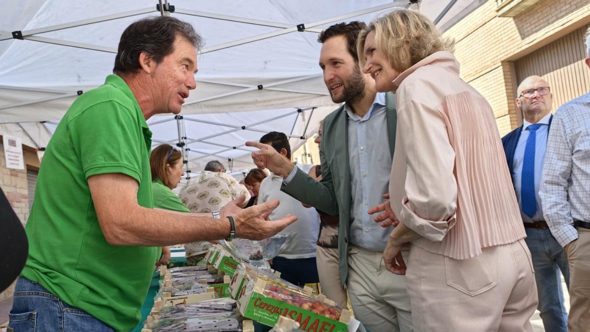 Isaac Claver y Maribel Bailo conversan con uno de los productores de cerezas.