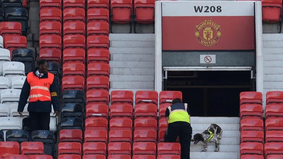 Miembros de seguridad rastrean las gradas de Old Trafford.