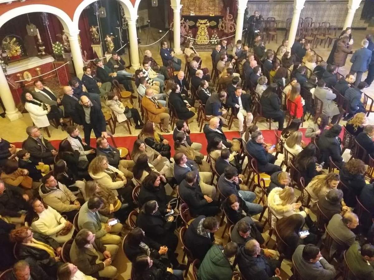 Público asistente al acto y algunos de los enseres de Semana Santa de la exposición que acoge el salón Génesis.