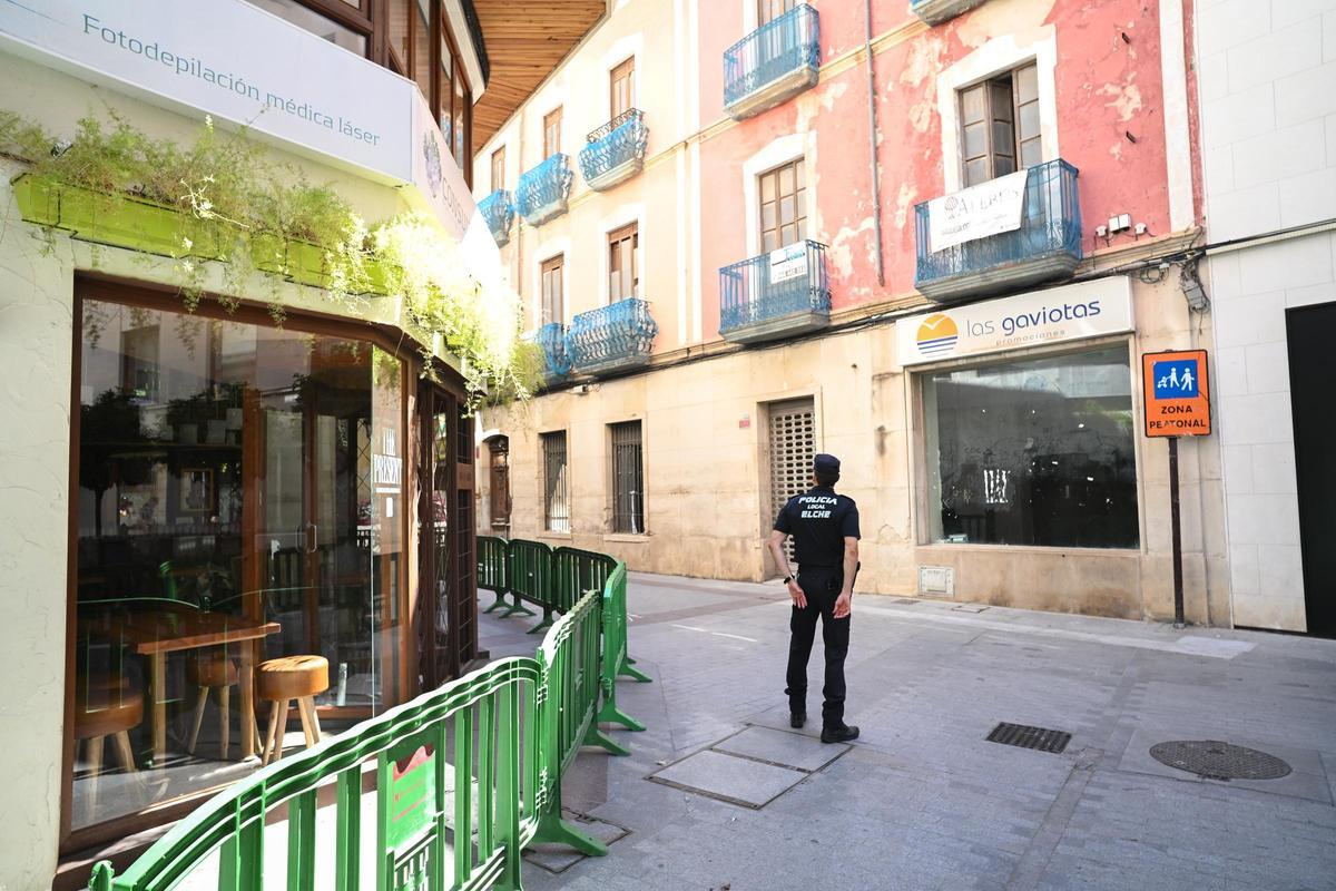 Un policía local frente a la fachada del edificio en Elche