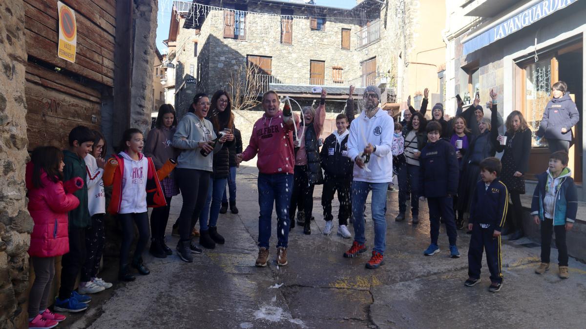 Un grup de veïns del poble de Ger (Cerdanya) celebrant que els ha tocat el segon premi de la rifa de Nadal davant el queviures on l'han adquirit