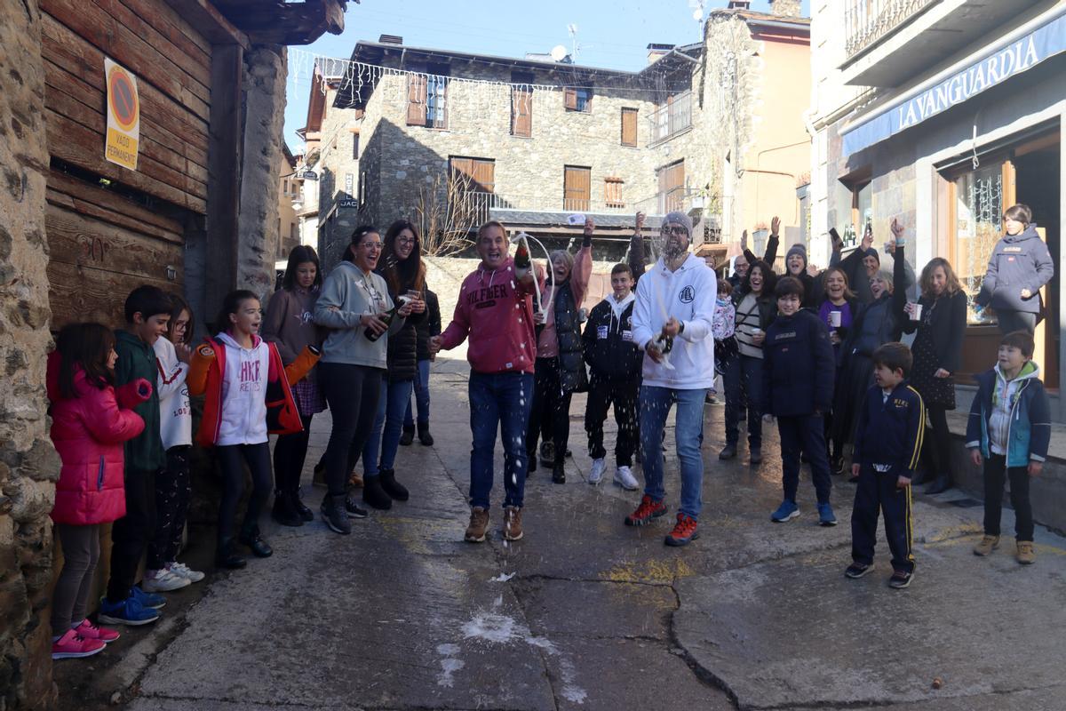 Un grup de veïns del poble de Ger (Cerdanya) celebrant que els ha tocat el segon premi de la rifa de Nadal davant el queviures on l'han adquirit