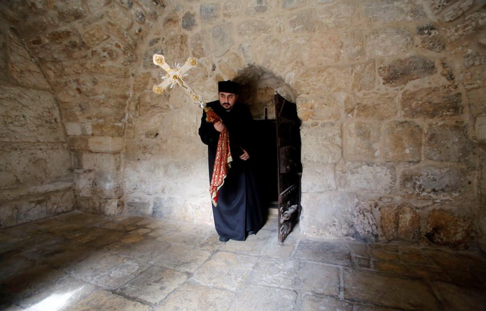 Clergyman holds a cross as he arrives to attend ...