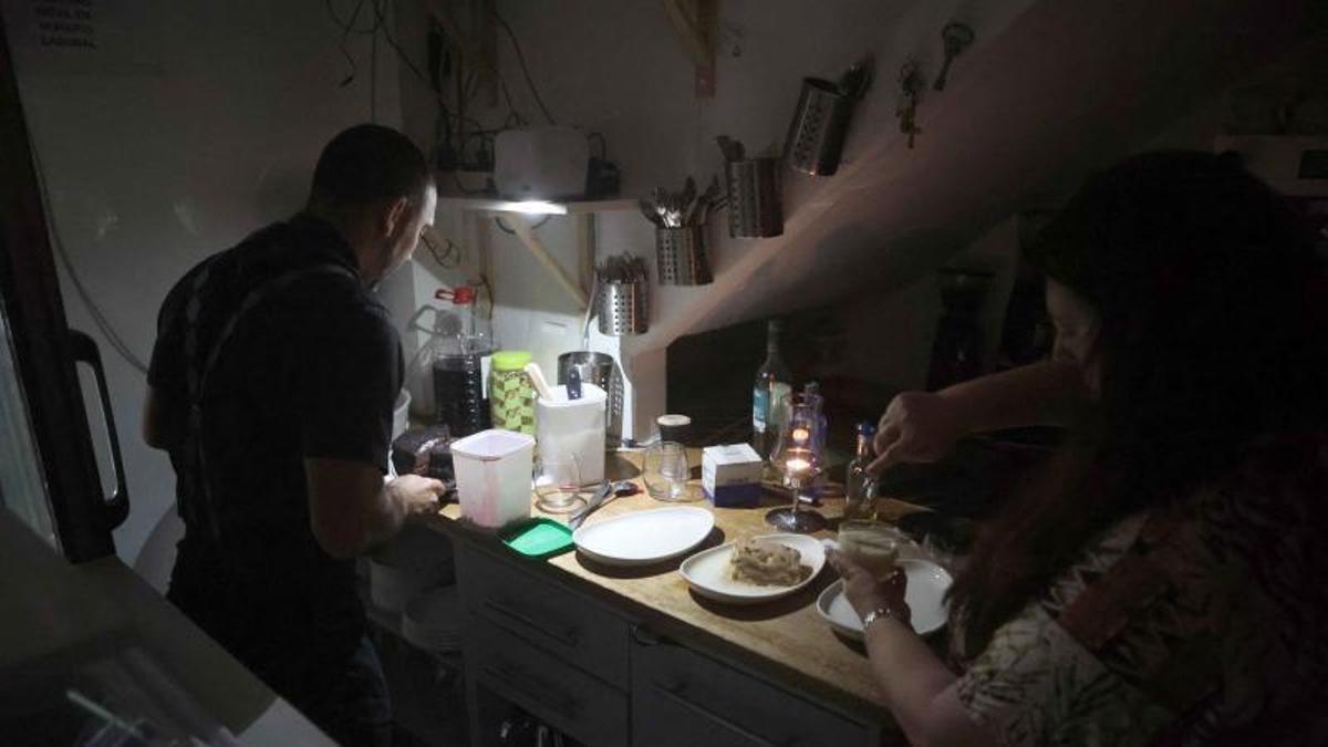 Unas personas, a oscuras en su casa pòr el apagón.