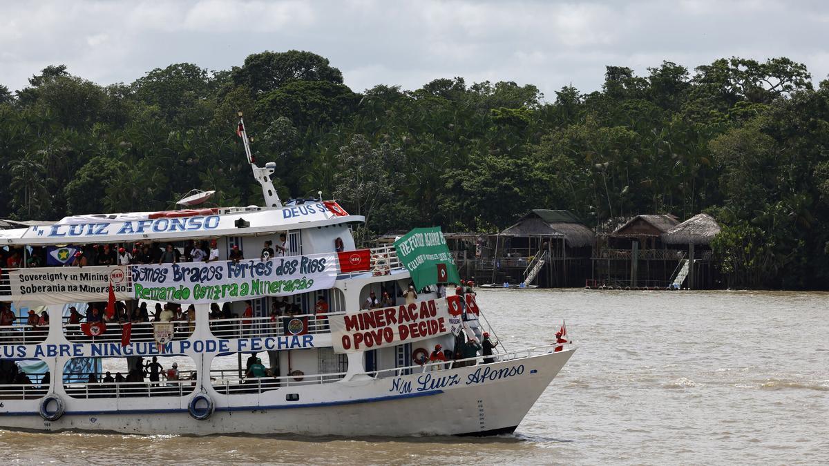 Una embarcación con integrantes de diversos movimientos sociales e indígenas navega por la bahía de Guajará con mensajes de protesta para la cumbre del clima de Belém (COP30).