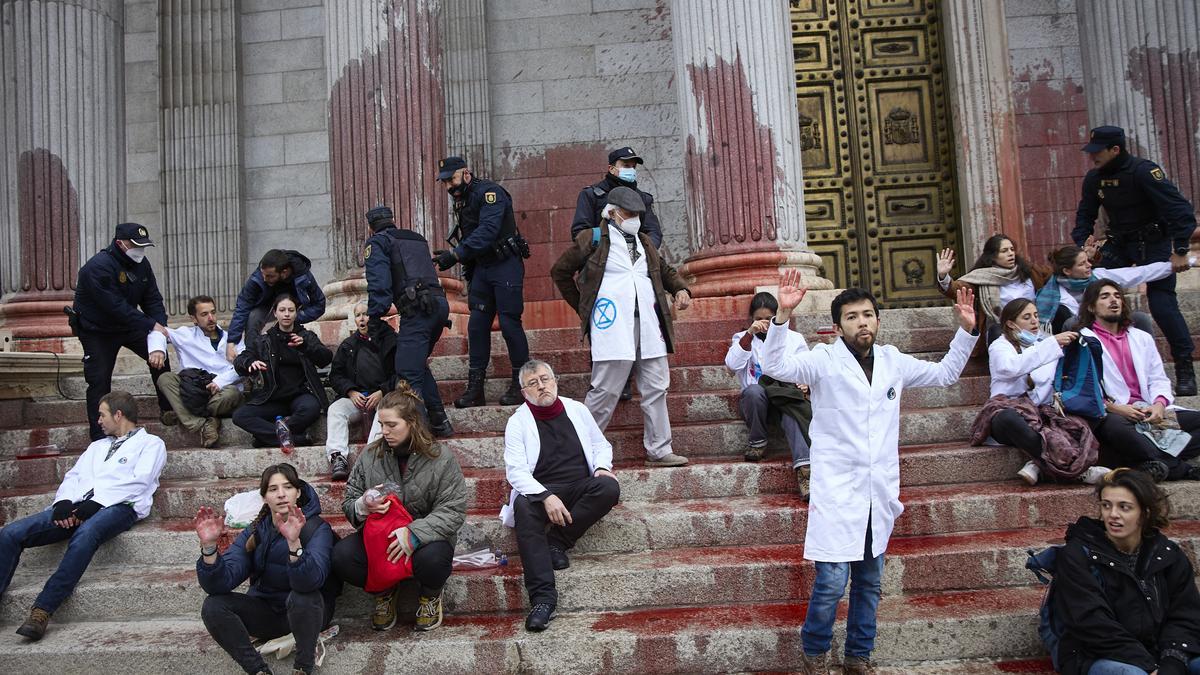 Polizisten räumen Demonstranten während einer Protestaktion der Gruppe «Rebelion cientifica» vor dem Parlament in Madrid. Die Demonstranten, Wissenschaftler, bewarfen das Parlamentsgebäude mit roter Farbe, um die Untätigkeit der Regierungen in Sachen Klimawandel anzuprangern.