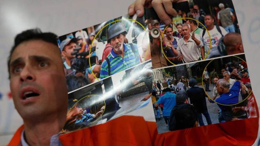 Capriles muestra fotos de las agresiones a opositores el pasado jueves.