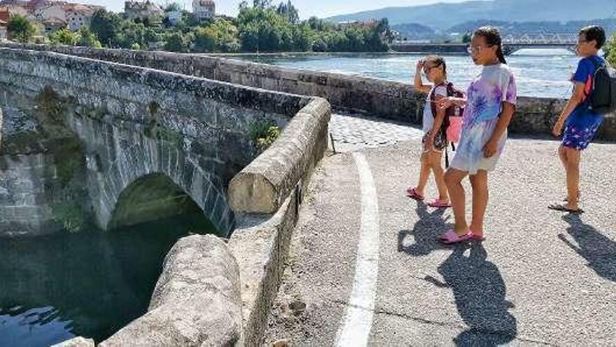 Unos niños observan los daños ocasionados en el puente. // S.A.