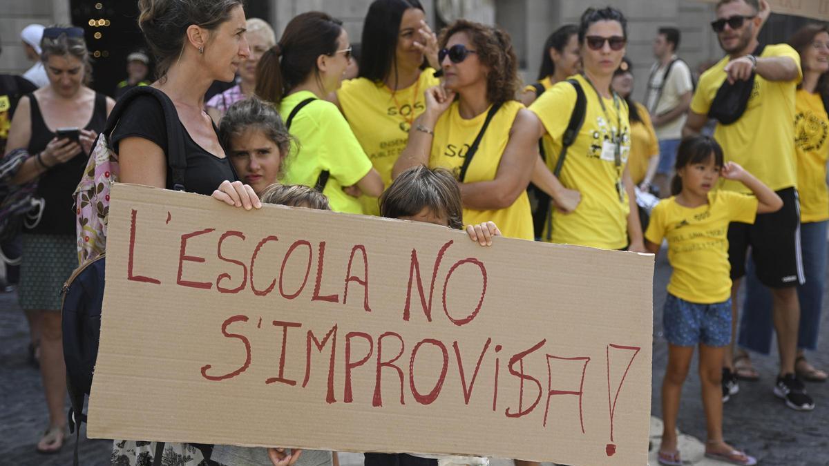 Una persona se manifiesta con una pancarta que reza:' L'escola no s'improvisa' durante la huelga de profesores de Catalunya el día que comienza el curso escolar, a 6 de septiembre de 2023, en Barcelona, Catalunya (España). Foto de archivo