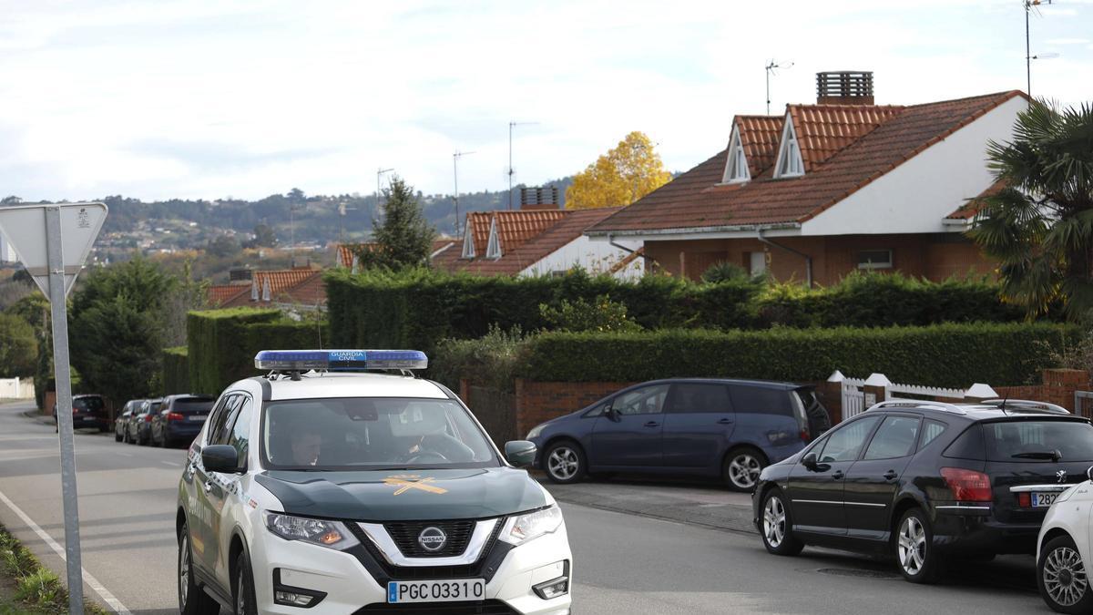 Un coche de la Guardia Civil patrullando junto a una urbanización en la zona rural de Gijón.