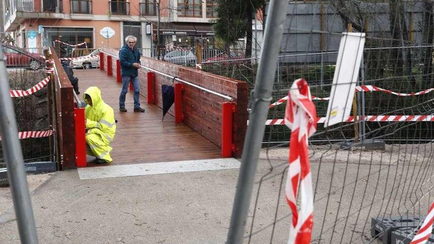 Los operarios ultimaban ayer la pasarela peatonal sobre el río Zamáns. // Jose Lores