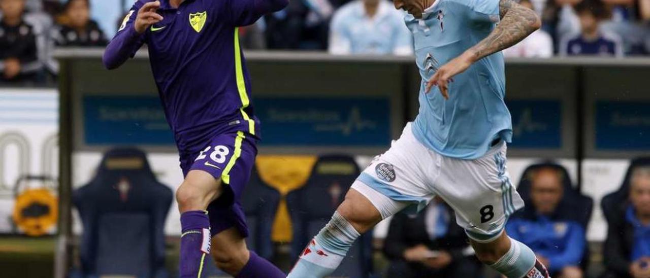 Pablo Hernández, el Tucu, conduce la pelota perseguido por el jugador venezolano del Málaga Juanpi durante el partido disputado ayer en Balaídos. // Ricardo Grobas