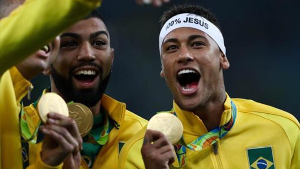 Neymar, con la medalla de oro, canta el himno de Brasil con sus compañeros.