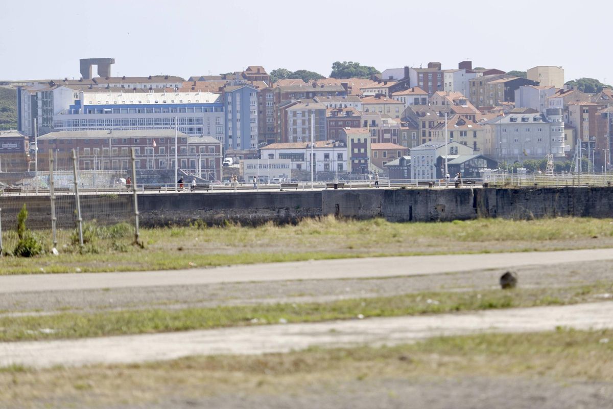 En primer término, vista de parte de los terrenos de Naval Gijón, con Cimadevilla y el Elogio del Horizonte al fondo.