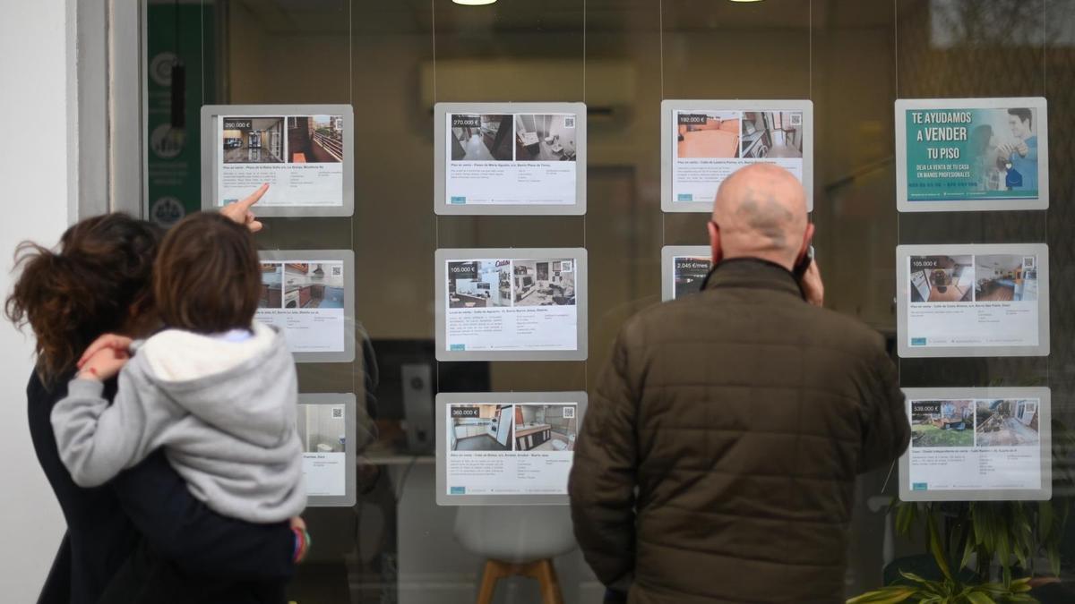 Varias personas, frente a los anuncios de una inmobiliaria en Zaragoza este jueves.