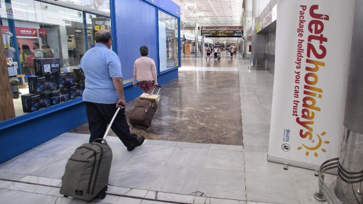 Dos viajeros caminan en el aeropuerto Tenerife Sur.