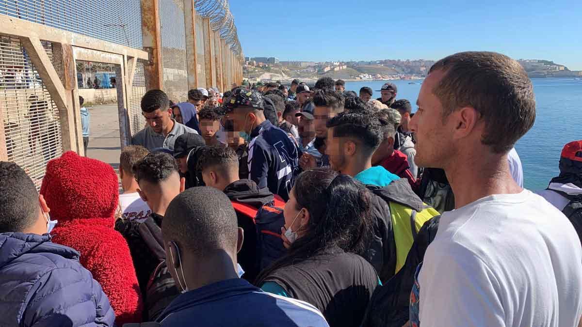 Un grupo de gente trata de cruzar la valla que separa Fnideq de Ceuta