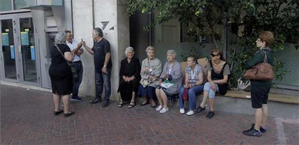 Ciutadans grecs fan cua davant una sucursal del Banc Nacional de Grècia, que s’ha llevat tancat avui, 29 de juny del 2015.