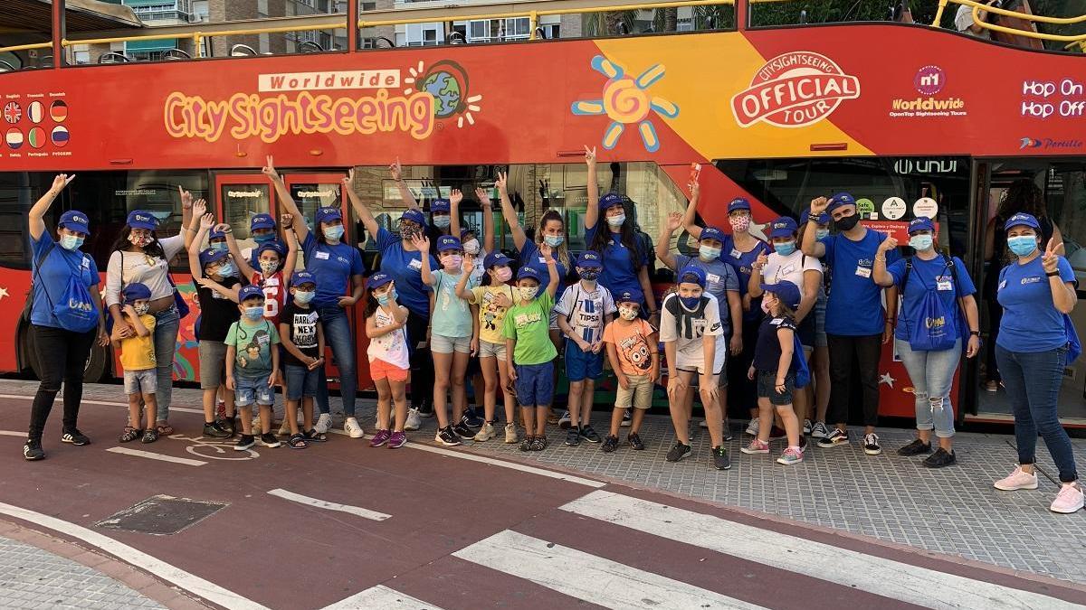 Monitores y niños del campamento de verano de Inpavi, en el autobús turístico.