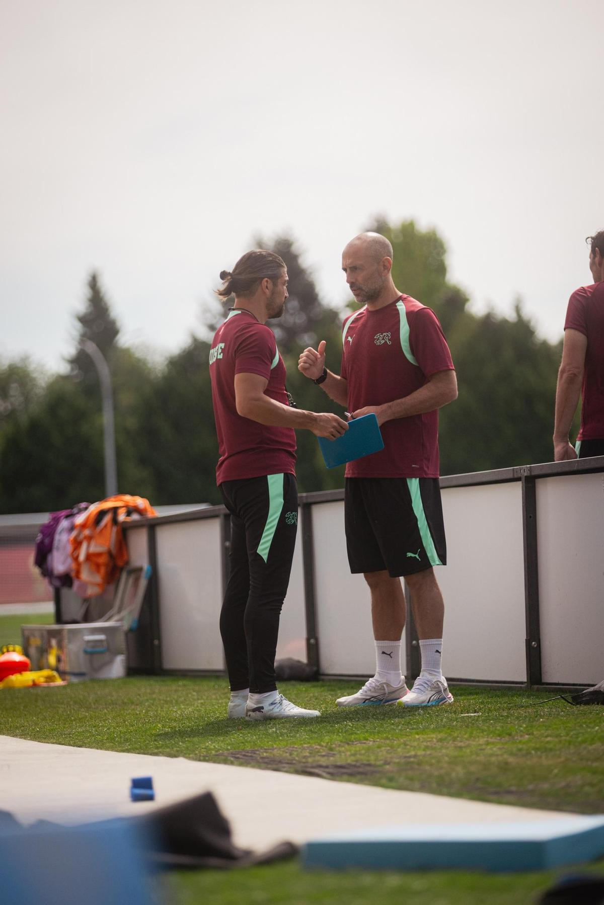 Parra habla con un futbolista en un entrenamiento.