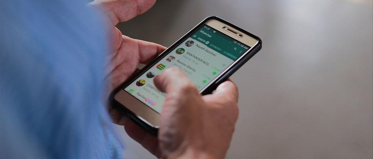 Un hombre usa la aplicación WhatsApp en su teléfono móvil.