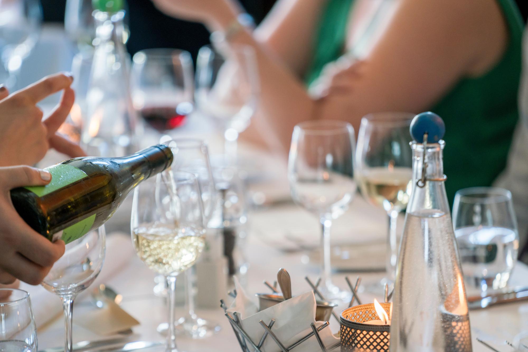 Un camarero sirve un vino durante una comida