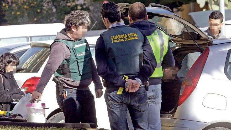 Agentes de la Guardia Civil tras descubrir un cubo lleno al parecer de cocaína en el coche del presunto jefe de una de las bandas.