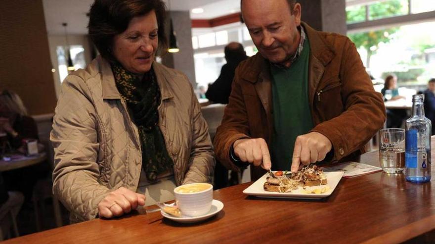 Marisa García y Joaquín Fernández degustan el pincho que sirvió la cafetería Cervantes, en El Entrego.