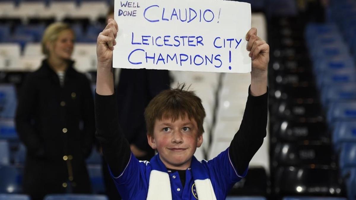 Niño aficionado del Leicester muestra una pancarta