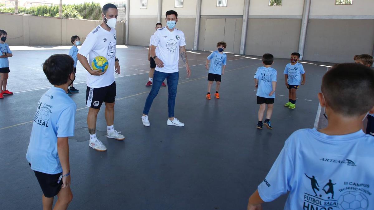 Manu y David Leal, junto a los niños participantes en su campus de fútbol sala, en Salesianos, este jueves.