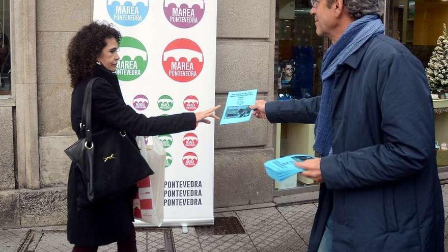 Luis Rei entrega un díptico de Marea a una ciudadana en la Plaza de A Peregrina. // Rafa Vázquez