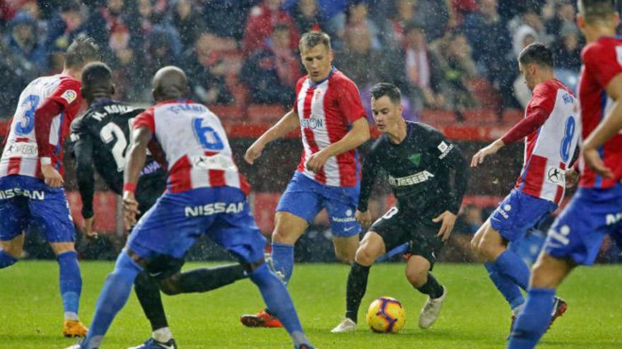 Juanpi Añor controla el balón bajo el diluvio de Gijón y rodeado de rivales en el duelo disputado ayer, donde provocó un penalti y marcó un gol.