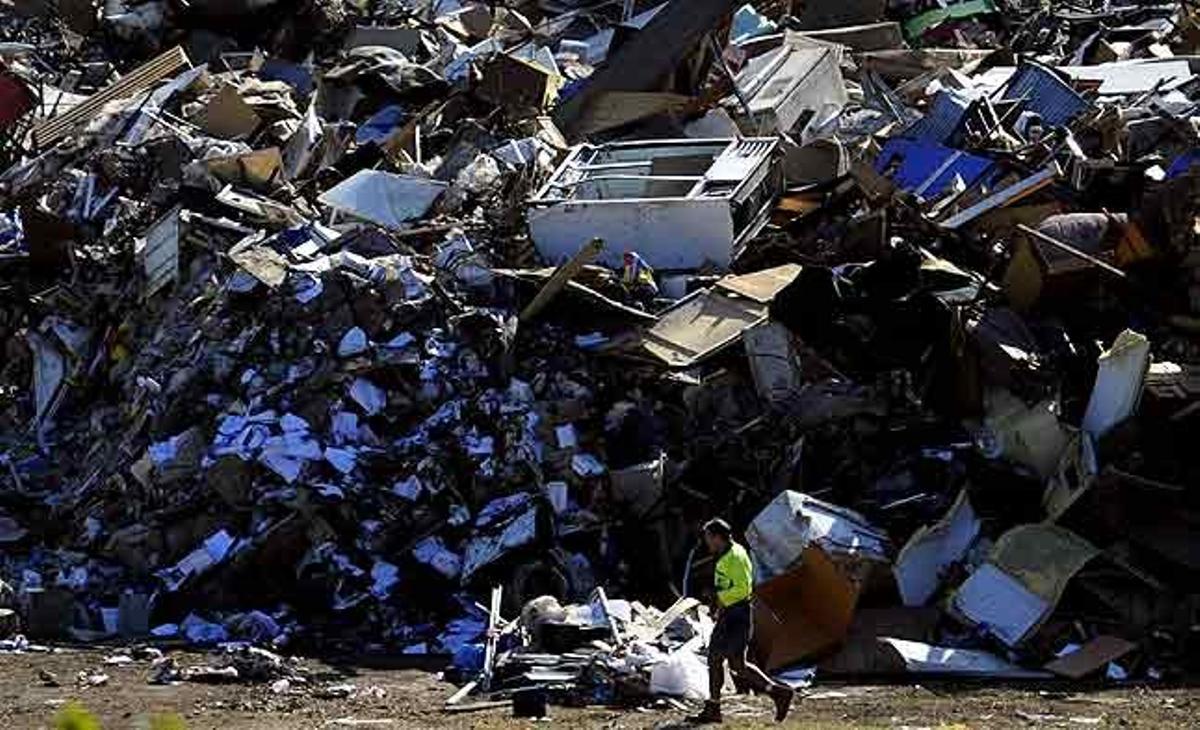 Un operari municipal de Brisbane passa al costat d’una muntanya de runa acumulada a prop d’unes instal·lacions esportives al club de golf Victoria Park a Brisbane (Austràlia).