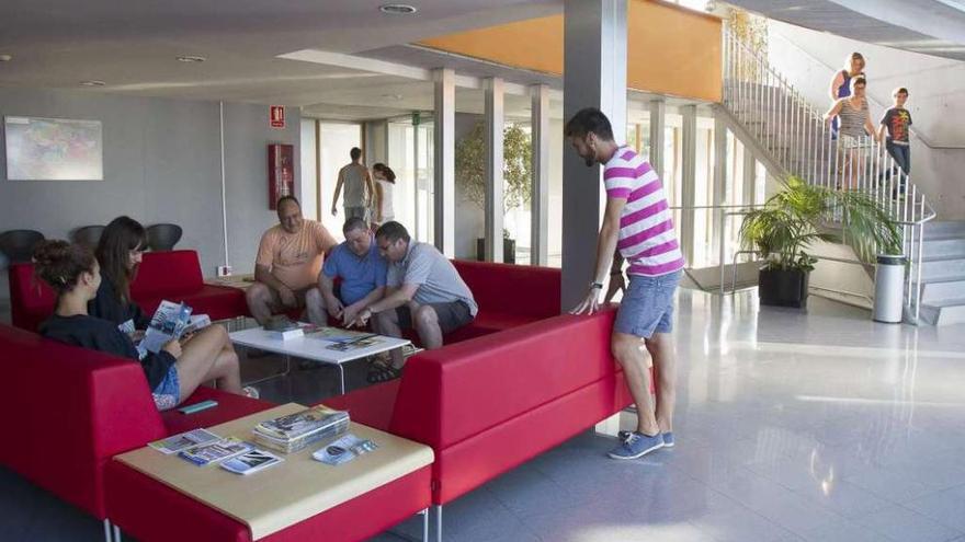 Turistas hospedados en la residencia universitaria del campus, ayer, en el vestíbulo.
