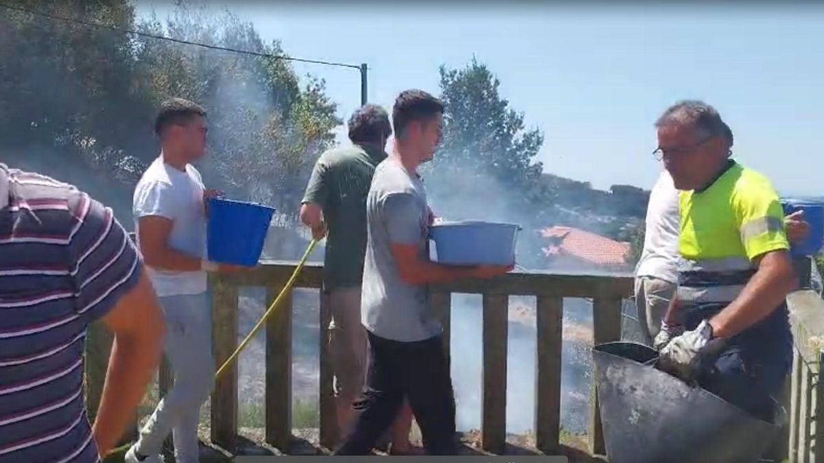 Vecinos de A Barraca en Bueu tratan de sofocar las llamas con calderos y agua de sus piscinas.