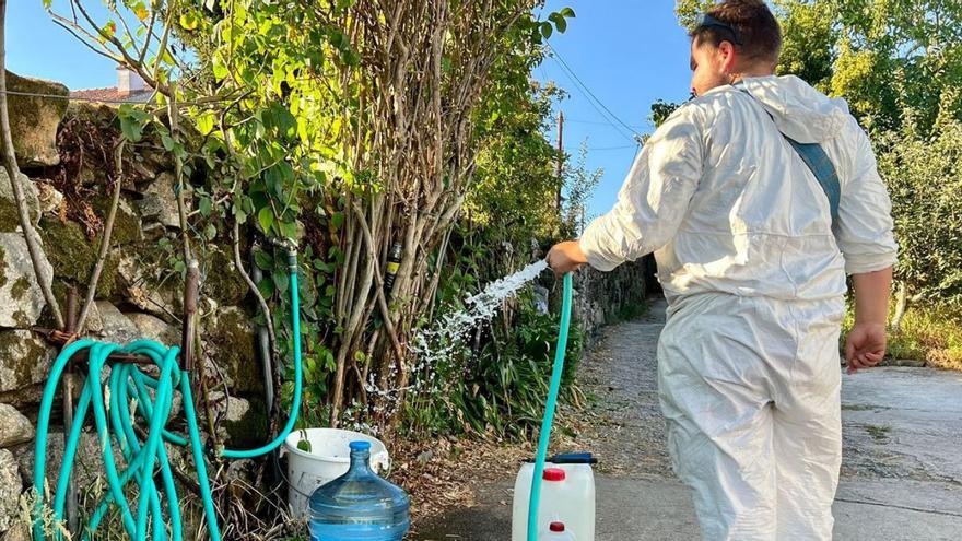 Un vecino de Vilaza recoge agua de la traída para dar de beber al ganado, ayer.  // D.P.