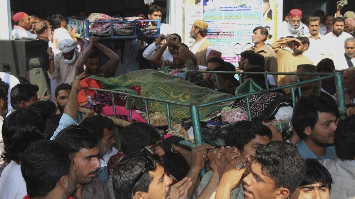 Familiares de varios asesinados asisten a su funeral tras el atentado suicida contra el templo sufí Lal Shahbaz Qalandar, en el sur de Pakistán, el 17 de febrero.